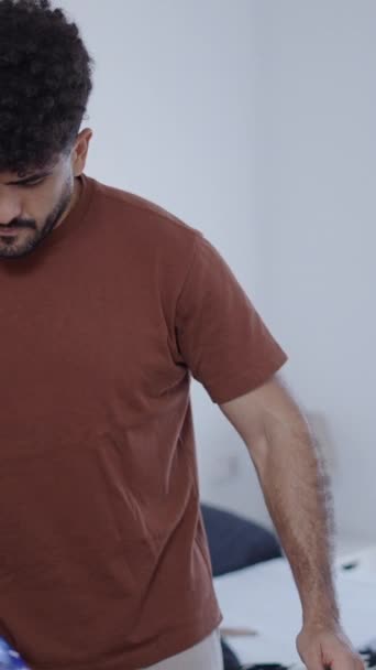 外出のために自分の服をアイロンをかけている男 Fhd 垂直ビデオ — ストック動画
