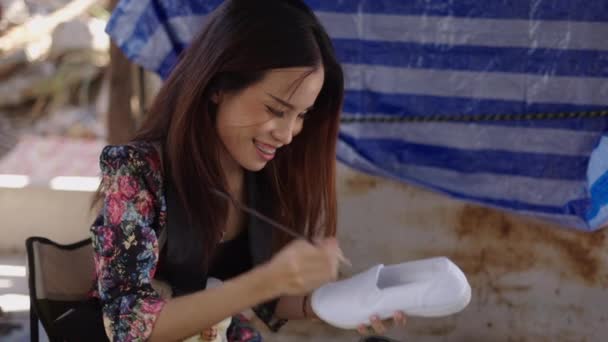 Una Chica Asiática Alegre Pinta Una Zapatilla Horizontal Video — Vídeos de Stock