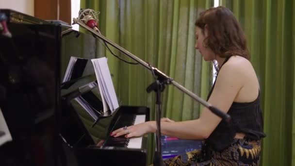 美丽的成年女子弹钢琴 并随着旋律的节奏移动 4K水平视频 — 图库视频影像