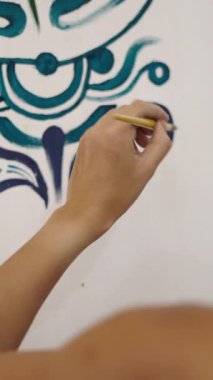 Tanınamayan ressam tuvale yeşil ve mavi bir resim çiziyor - FHD dikey video