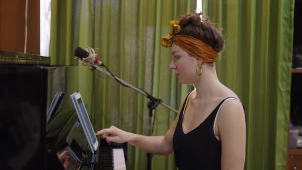 화려한 코카서스 소녀는 그녀의 태블릿에 무언가를 피아노를 비디오 — 비디오