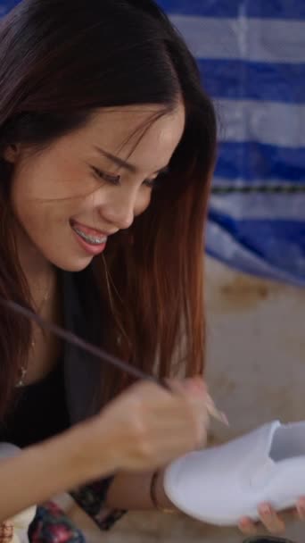 Ein Fröhliches Asiatisches Mädchen Malt Einen Pantoffel Fhd Vertikales Video — Stockvideo