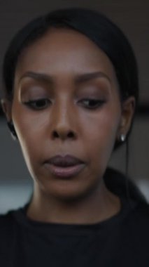 Bir koşu bandında koşarken kulaklık kullanan Afro-Amerikalı bir kadının fHD dikey video konseptini kapatın.