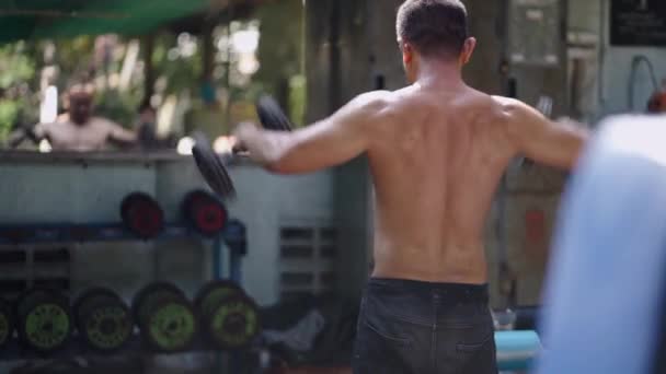 一个无法辨认的人举重锻炼他的肩膀 4K卧式地方街头体操馆 — 图库视频影像