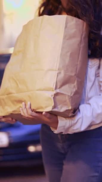ショッピングの後でプロダクトが付いているブラウンのペーパー袋を握る少女は家に行く クローズアップ 1080 — ストック動画