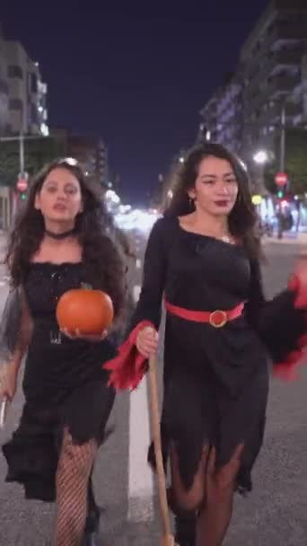Boszorkányjelmezes Lányok Sétálnak Úton Sütőtököt Seprűnyélt Tartanak Kezükben Táv Lövés — Stock videók