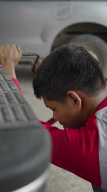 Asyalı bir adam FHD HORIZONTAL VIDEO ile arabadan bir şey sıkıyor.