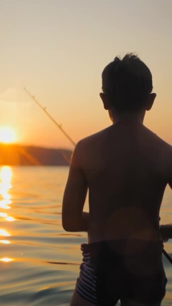 Ein Unkenntlich Gemachter Junger Fischer Unter Einem Sonnenuntergang Fhd Vertical — Stockvideo