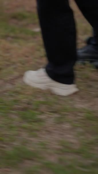 一双腿和一双运动鞋在草地上同步行走 低角度视图 垂直1080视频 — 图库视频影像