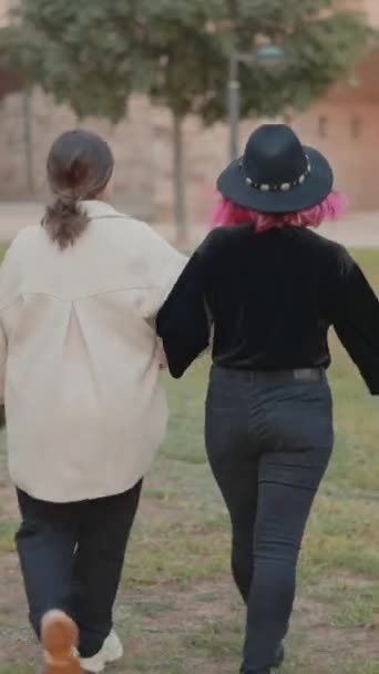 Rear Tracking View Two Stylish Girls Wandering Park Holding Hands — Stok Video