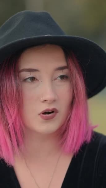黒い帽子を使った素敵なピンクハイレッドの女の子が別の女の子と話す 肩のショットの上に閉じる 垂直1080ビデオ — ストック動画