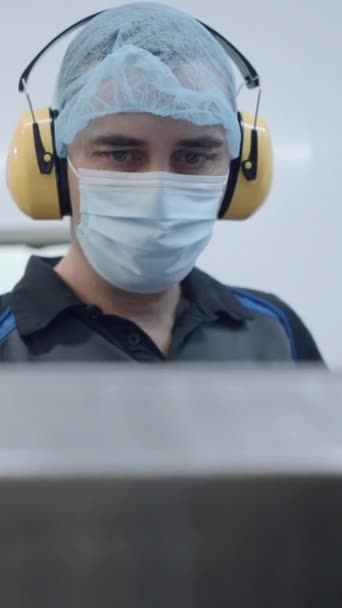 Männlicher Arbeiter Mit Maske Haarnetz Und Kopfhörer Während Des Betriebs — Stockvideo