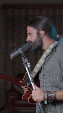 Manly bearded man finishing an online concert at home - Middle shot