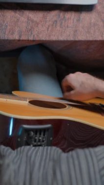 Hands of a musician playing guitar in a home made studio - Close up movement shot