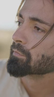 Gitar çalarken yana bakan sakallı İspanyol adamın üzgün yüzü - yavaş çekim - Dikey FullHD video