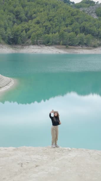 Gadis Berdiri Oleh Danau Pirus Dan Mengambil Selfie Dengan Telepon — Stok Video