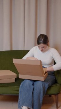 Karton kutularda siparişleri paketleyen bir kadın. Teslimat için kadın girişimci paketleme ürünleri. - Dikey FullHD video
