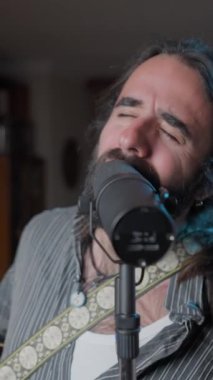 Young bearded vocal coach teaching how to sing online to his audience - Close up to wide shot