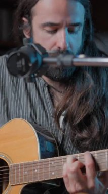 Caucasian musician playing a guitar song online in his YouTube studio - Close up shot