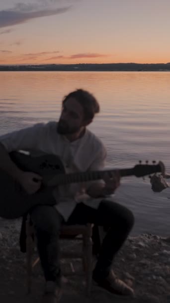 Silueta Kytaristy Hrajícího Akordy Akustickou Kytaru Jezera Při Dramatickém Západu — Stock video