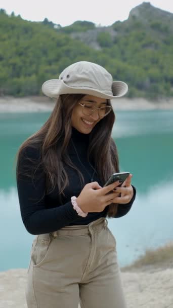 Chica Con Sombrero Gafas Toma Selfie Utiliza Teléfono Por Lago — Vídeo de stock
