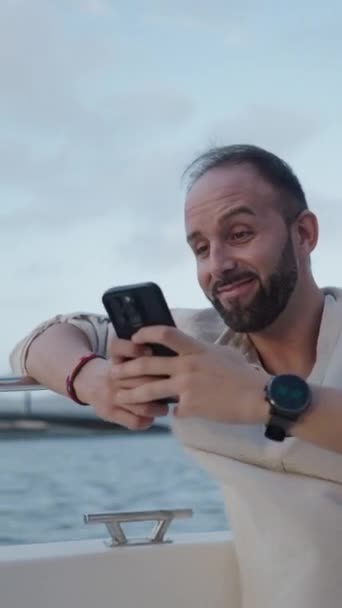 Boy Bersenang Senang Sambil Melihat Sesuatu Ponselnya Dalam Sebuah Perahu — Stok Video