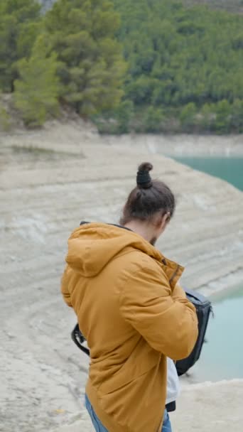 Mladý Muž Vytáhne Kameru Batohu Vyfotí Jezero Španělsku Vertikální Video — Stock video