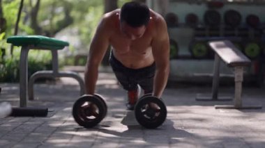Sokak spor salonunda bir adam tekerlek üzerinde çalışır - 4K Yatay Yerel Spor Salonu