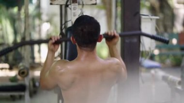 Tanınmayan bir adam açık hava spor salonunda sırtını çalıştırıyor - 4K Yatay Yerel Spor Salonu