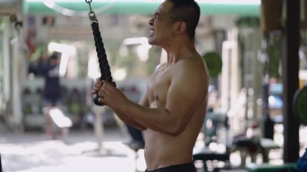 Asiatischer Starker Mann Bei Einer Trizepsübung Mit Dem Flaschenzug Horizontal — Stockvideo