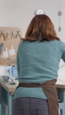 Yetenekli genç bir zanaatkar, küçük not defterine suç ortağı olarak bakıyor. Orta Çekim FullHD Dikey Video