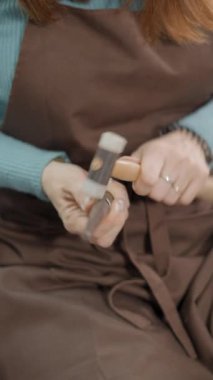 Mücevher yapmak için çekiç şekillendirme malzemesi olan kadın bir zanaatkarın mahsulü görüntüsü. FullHD Dikey Videoyu Kapat