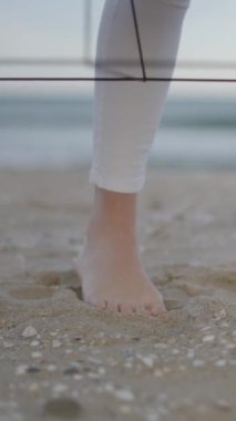 Sahilde yalınayak duran tanınmayan bir kadının ayakları. Tenim kuma değiyor. Tanımlanamayan masör - FullHD Dikey Video