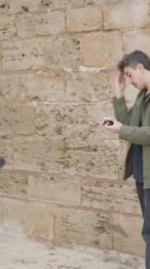 Profesyonel film analog fotoğrafçısı ve kaprisli erkek model moda dergisi ya da ticari reklam için açık hava fotoşopu. - FullHD dikey video