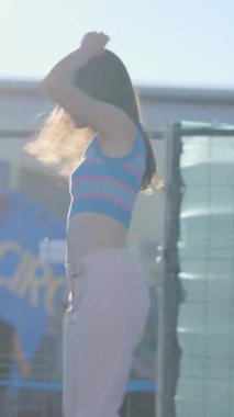 Koyu renk saçlı genç kadınlar gün ışığında paten kayarak dönüyorlar - FullHD dikey video