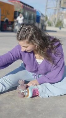 Renkli elbiseli ve patenci kız bacaklarını yere uzatıyor - FullHD dikey video