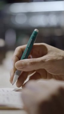 Lokanta tezgahındaki not defterine erkek el yazısı yakın plan - FullHD dikey video