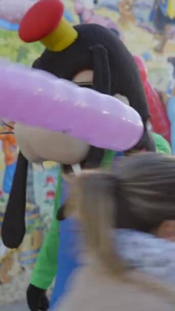 身着高飞和米老鼠服装的男人们在 Tren Chu Chu 景点用气球招待孩子们 游客们乘坐一辆小型火车在瓦伦西亚 Fullhd垂直视频游乐场 — 图库视频影像