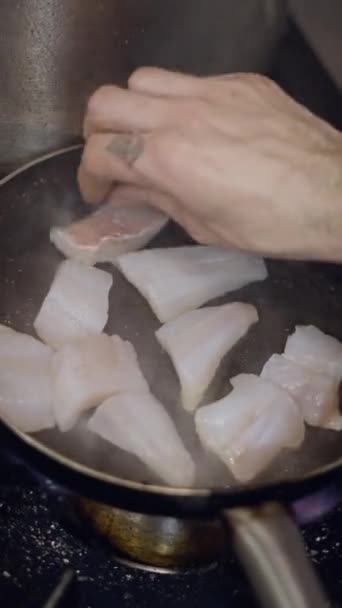 フライパンに白い魚を置く入れ墨された男性シェフの近いビュー フルHd垂直ビデオ — ストック動画