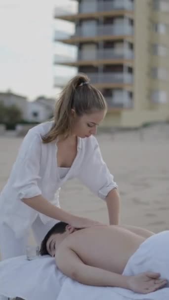 Jonge Volwassen Man Ontspant Het Strand Krijgt Massage Van Professionele — Stockvideo