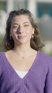 Koyu renk saçlı, açık havada lolipopu olan kızın yakın görüntüsü - FullHD dikey video