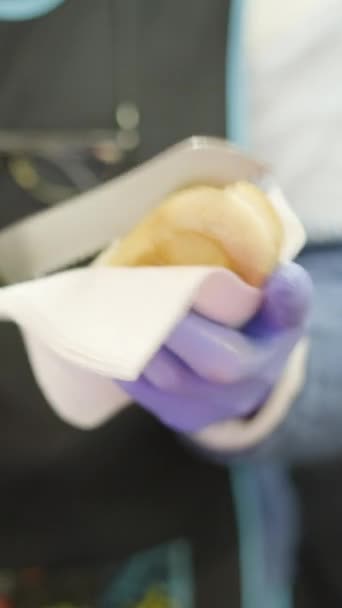 バレンシアのストリートマーケットの楽しみの束を切るホットドッグを準備するゴム手袋の女性の手 Fullhd垂直ビデオ — ストック動画