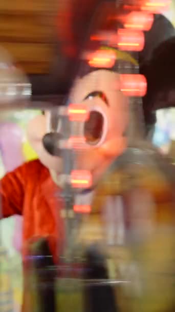 バレンシアファンフェア ミッキーマウスのスーツの男は インフレーションバルーンと子供を楽しませる トレンチャック アトラクションで電車に乗って訪問者を蹴る Fullhd垂直ビデオ — ストック動画