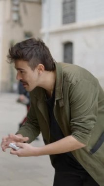 Sihirbaz adam kartlarla sokak sihirbazlığı numarası yapıyor. - FullHD dikey video