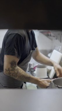 Lokanta mutfağında çalışan erkek aşçı, duvardaki delikten geçen Slomo - FullHD dikey video
