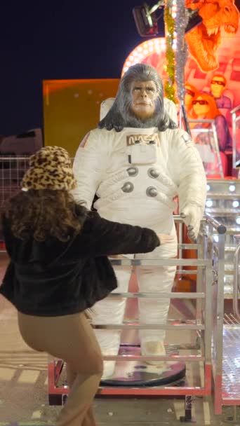 宇宙飛行士のスーツでゴリラの若い女性のキス彫刻を楽しみ バレンシアで面白いポーズを作る スローモーション フルHd垂直ビデオ — ストック動画