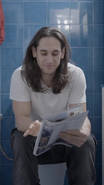 Young Caucasian Man Reading Newsletter Bathroom While Shit Frontal Shot — Stock video
