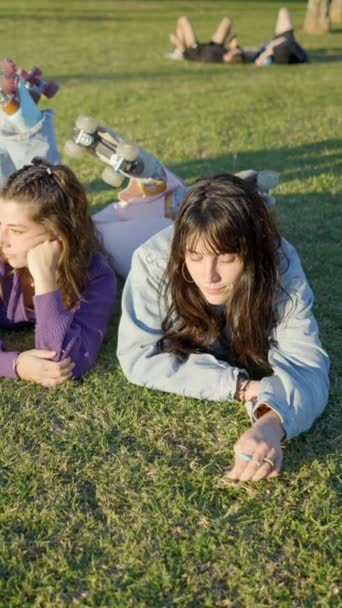 Three Girls Wearing Roller Skates Lie Lawn Sunlight Talk Fullhd — Stock Video