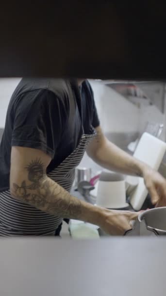 男性シェフはレストランキッチンで働いています 壁の穴を通してスロモー Fullhd垂直ビデオ — ストック動画