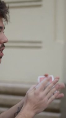 Profesyonel sokak sihirbazı etkileyici bir el kartı hilesi sergiliyor. - FullHD dikey video